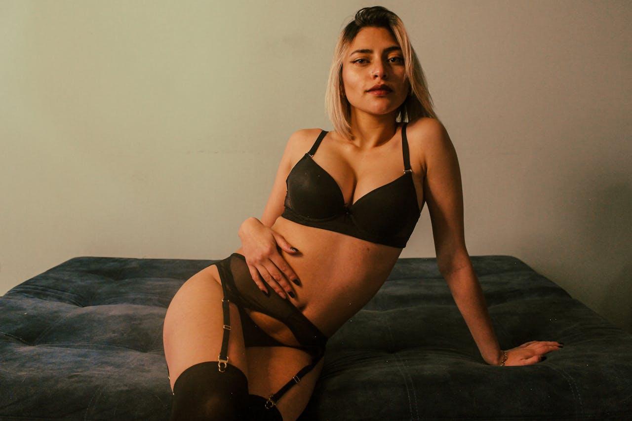 Elegant woman modeling black lingerie indoors, exuding confidence and empowerment.